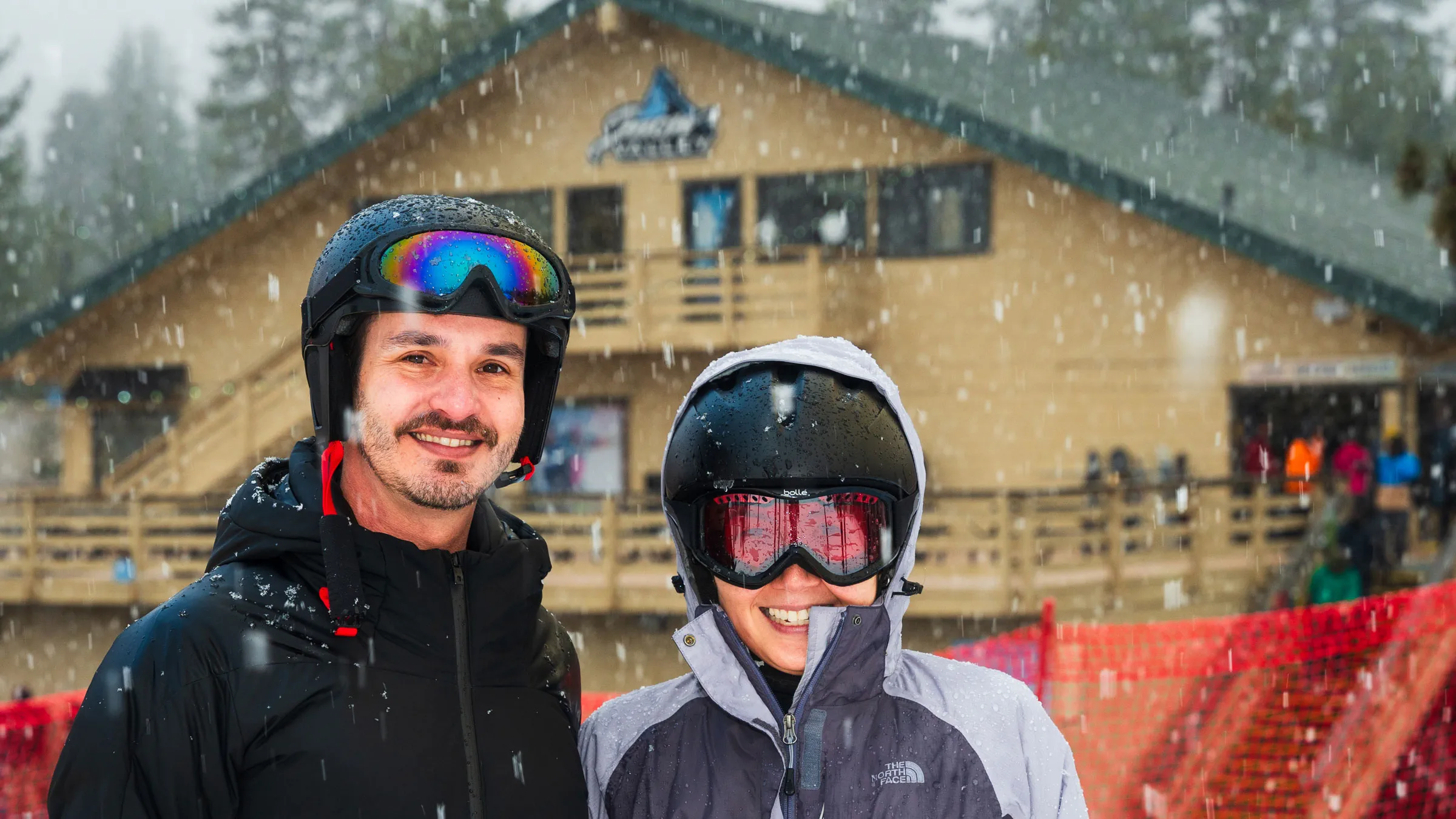 Two adults in snow gear smiling for new snow at Snow Valley